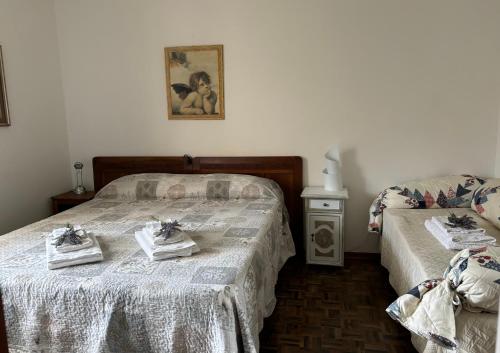 una camera da letto con due letti con asciugamani sopra di Sensory Garden a San Daniele del Friuli