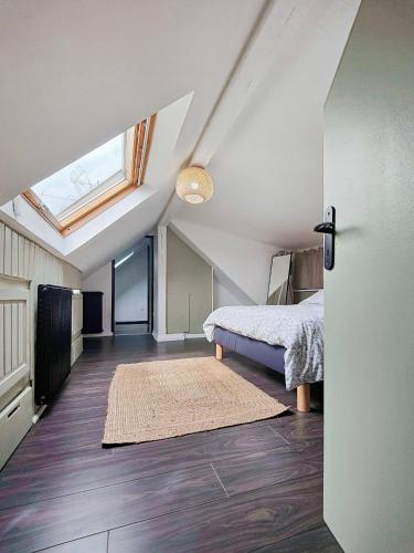 sypialnia na poddaszu z łóżkiem i oknem w obiekcie Appartement Le Baroque en duplex w Miluzie