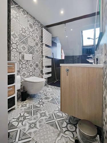 une salle de bain avec une baignoire, des toilettes et un lavabo dans l'établissement Appartement Le Baroque en duplex, à Mulhouse