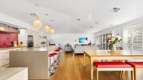 a kitchen and living room with a table and chairs at Marleys Retreat in Patonga