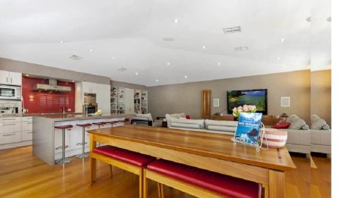 a kitchen and living room with a large wooden table at Marleys Retreat in Patonga