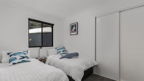a bedroom with two beds and a window at Jewelers Retreat in Pearl Beach