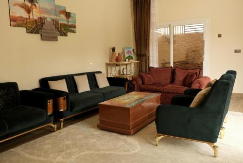 a living room with couches and chairs and a table at Alshuruq Stay in Al Ḩamrāʼ