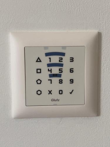 a white lightswitch on a white wall with a calculator at B&B Cà Nosa in Gordevio