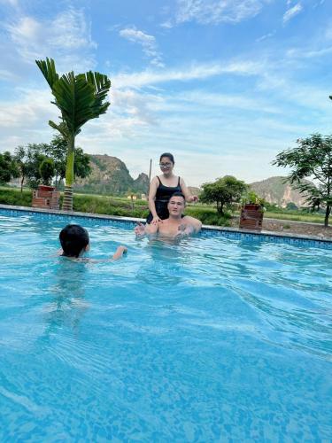 a woman and a man in a swimming pool at Tam Coc Moutainside Homestay in Ninh Binh