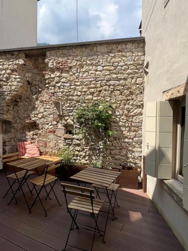 a patio with two tables and chairs and a stone wall at Follinetta10 - enjoy holiday home in the Prosecco hills in Follina