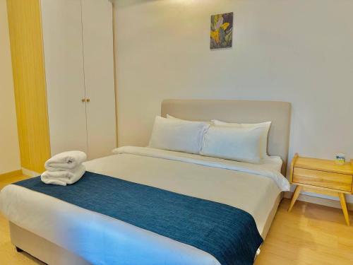 a white bed with a towel on top of it at Mutiara Melaka Beach Resort by Glex in Tangga Batu