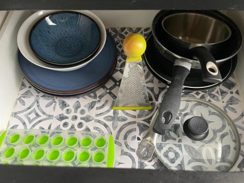 un comptoir de cuisine avec un évier avec de la vaisselle et une passoire dans l'établissement BLUE Home, à Besançon