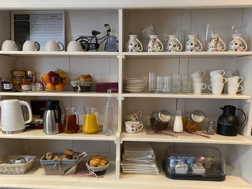 a shelf filled with lots of dishes and cups at Hotel Saint Yves in Nantes