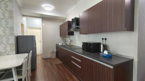 a kitchen with a counter top and a refrigerator at SAFIYA Homestay Vista Alam in Shah Alam