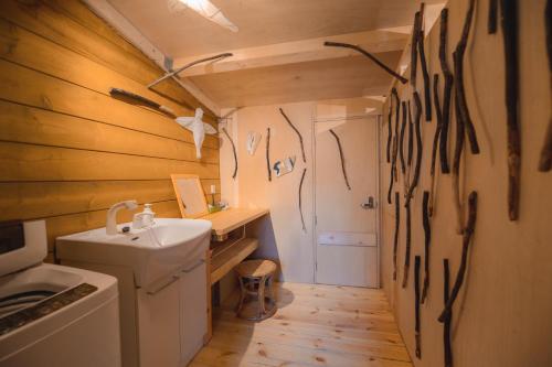 a bathroom with wooden walls and a sink and a toilet at Artemina Kussharoko Log Terrace in Teshikaga