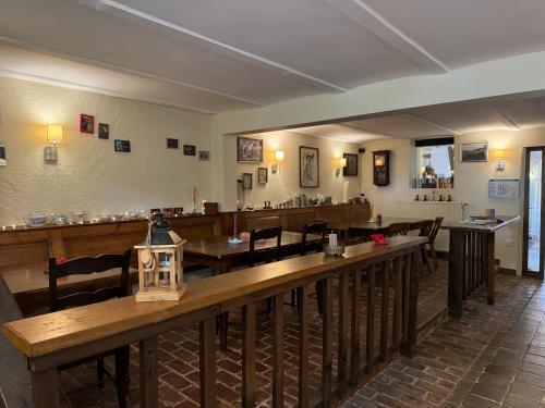 a restaurant with a bar with wooden tables and chairs at Hinkelshof - als Ferienwohnung - Selbstversorgerküche & Aufenthaltsräume - Südeifel, Mullerthal, Vianden in Körperich
