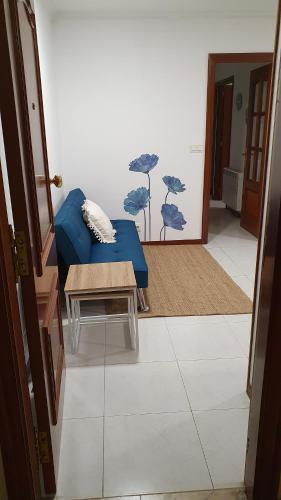 a living room with a blue couch and a table at Arenales Azules in Baiona