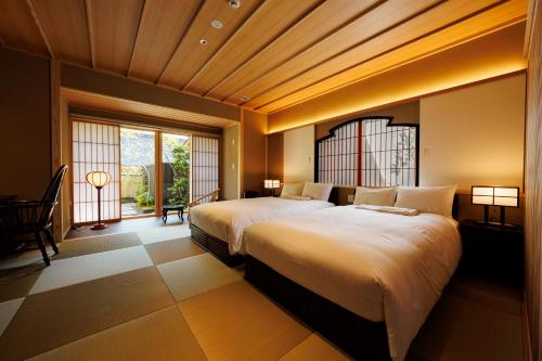 a bedroom with two beds and a large window at Shoraiso in Yamanouchi