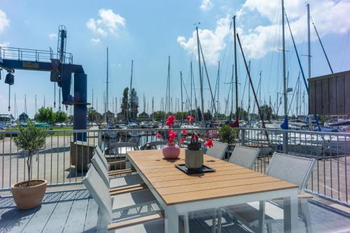 a table and chairs on a deck with a marina at Roggebroek 44 in Stavoren