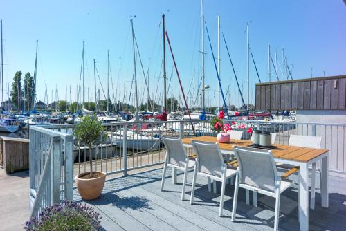 a table and chairs on a balcony with a marina at Roggebroek 44 in Stavoren