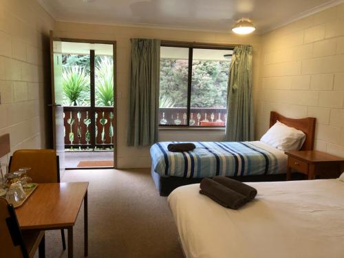 a hotel room with two beds and a table at Green Gables Motel in Warburton in Warburton