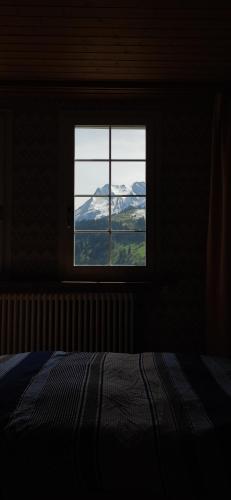 a bedroom with a window with a view of a mountain at Gasthaus Stausee in Innerthal