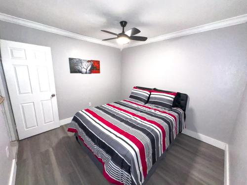 a bedroom with a bed with a striped blanket at Luxury home 5 minutes from stadium in Miami