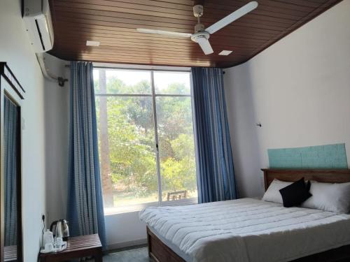 a bedroom with a bed and a large window at Esha Beach Resort Rooms in Trincomalee