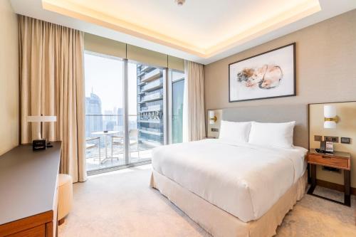 een hotelkamer met een bed en een groot raam bij Luxe 3-BR in Address Dubai Opera with Full Burj View in Dubai