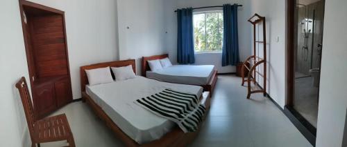 a bedroom with a bed and a mirror and a window at Esha Beach Resort Rooms in Trincomalee