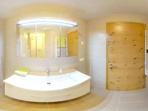 a bathroom with a large white tub and a mirror at 3 Gerlitzen - at Lake Faak Karglhof in Faak am See