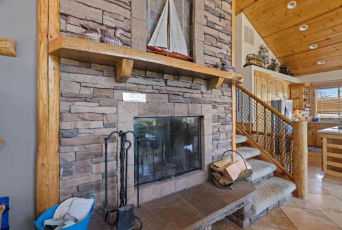 a stone fireplace in a living room with a staircase at Chinook House MCA 1219 - Meredith Lodging in Manzanita