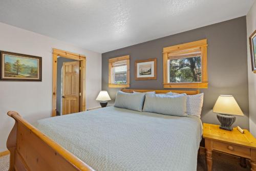 a bedroom with a bed and two lamps and two windows at Chinook House MCA 1219 - Meredith Lodging in Manzanita