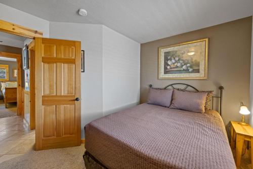 a bedroom with a bed and a wooden door at Chinook House MCA 1219 - Meredith Lodging in Manzanita