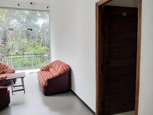 a room with two chairs and a window at Esha Beach Resort Rooms in Trincomalee