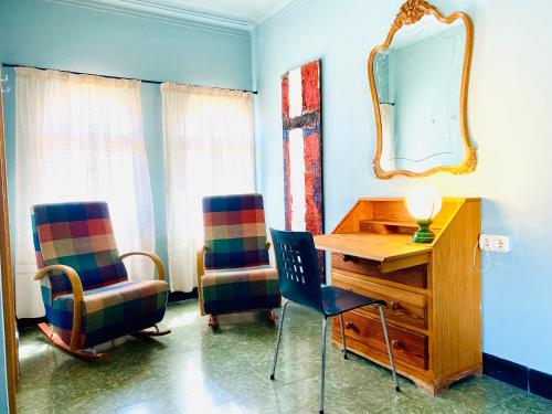 a room with two chairs and a desk and a mirror at Carmen Guillemot in Alcanar