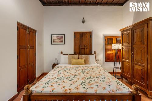 a bedroom with a large bed with wooden cabinets at CVM House with Lawn at Thiruvalla by StayVista in Alleppey