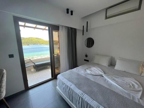 a bedroom with a bed and a view of the ocean at Blue Green Bay in Panormos Skopelos