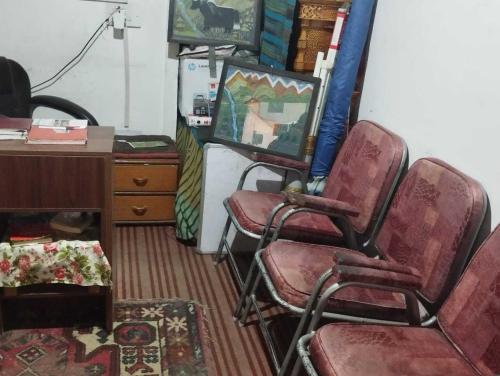 a room with three chairs and a desk and a desk at Hotel O Gongma Guest House in Leh