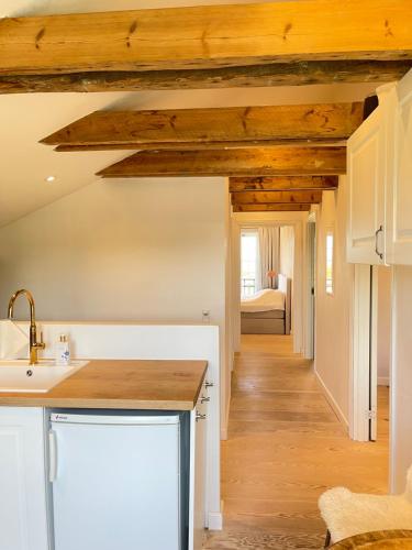 a kitchen with wooden ceilings and a bedroom with a bed at Eksklusiv taglejlighed med hav- og skovudsigt in Risskov