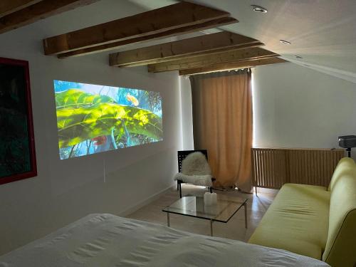 a living room with a couch and a tv on the wall at Eksklusiv taglejlighed med hav- og skovudsigt in Risskov