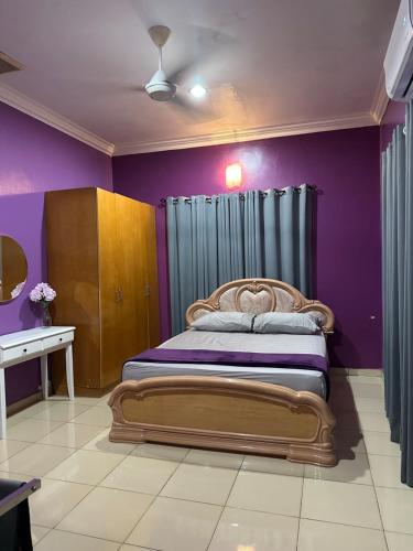 a bedroom with a large bed with purple walls at ARY&ZZ Homestay for islam guests in Tanjung Karang
