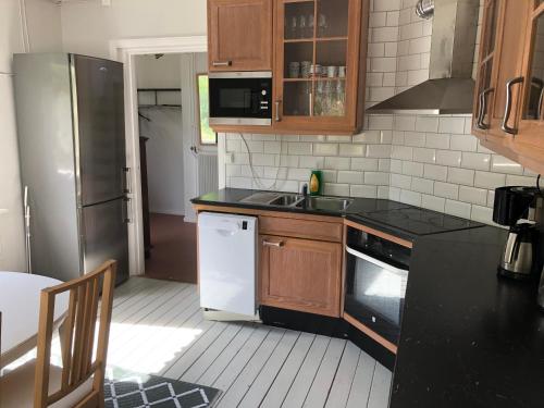 a kitchen with a sink and a refrigerator at Villan med egna sovrum för de flesta in Västervik