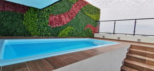 einem Pool vor einer Pflanzenwand in der Unterkunft Hermoso departamento para vacacionar in Mazatlán