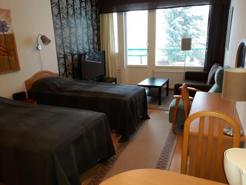 a hotel room with two beds and a living room at Ikaalisten kylpylä-hotelli in Ikaalinen