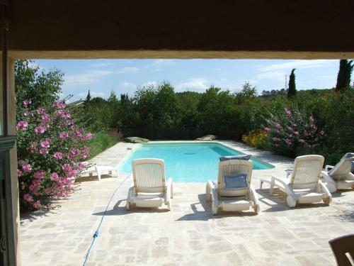 - un groupe de chaises et une piscine dans l'établissement la galouciere, à Saint-Just-et-Vacquières