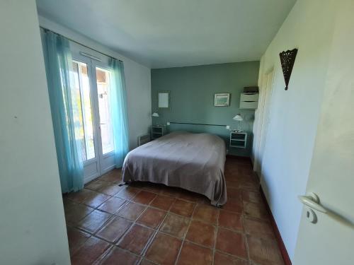 une chambre avec un lit et une fenêtre dans l'établissement la galouciere, à Saint-Just-et-Vacquières