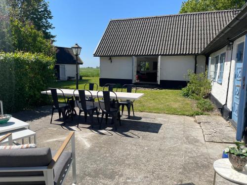 a patio with a table and chairs and a building at Generös skånegård i idylliska Örum in Löderup