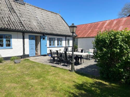 a table and chairs in front of a house at Generös skånegård i idylliska Örum in Löderup