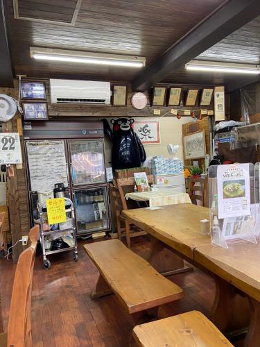 a store with wooden tables and benches in a room at カモンイン 寿 in Izumi