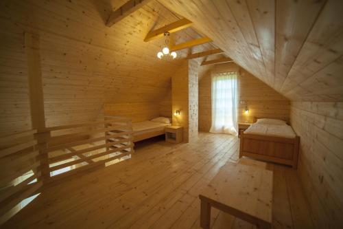 a large wooden room with a bed and a window at Holiday Homes Eko Klanac in Rakovica