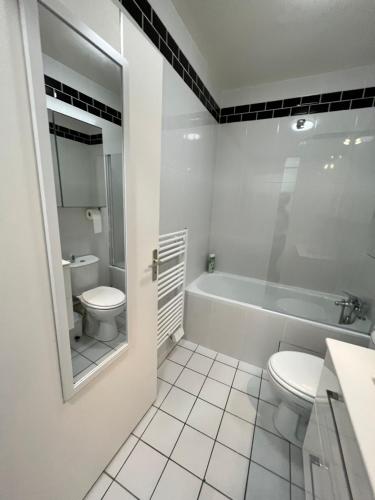 une salle de bain blanche avec toilettes et baignoire dans l'établissement Charmant duplex T3 proche de Paris & Versailles, à Bois-dʼArcy