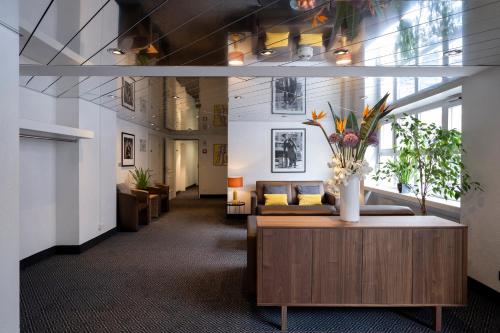 a lobby with a couch and a vase of flowers at Hotel Stoller in Zürich