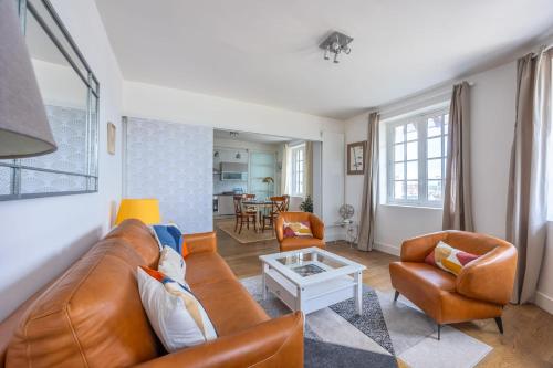un salon avec un canapé et une table dans l'établissement Appartement Les Goélands - Welkeys, à Trouville-sur-Mer